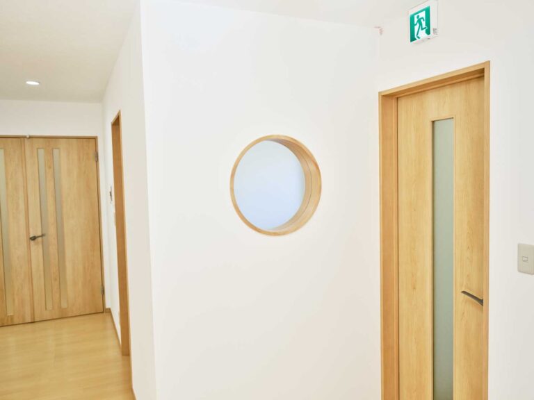 玄関から入ってきた子どもが見える丸い窓