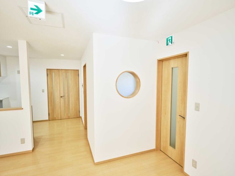 玄関から入ってきた子どもが見える丸い窓